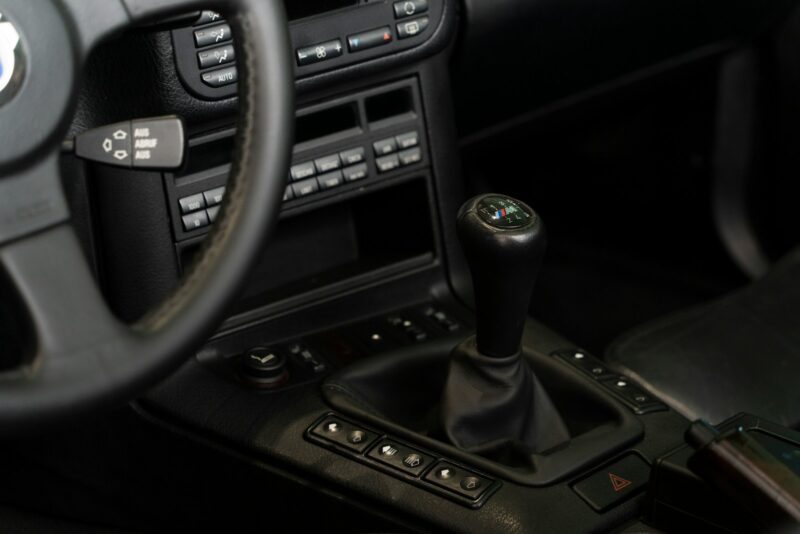 Manual Transmission Control in Car Interior – Vehicle Gear Shift and Dashboard Interior of a car showcasing a manual gear shift and control buttons.