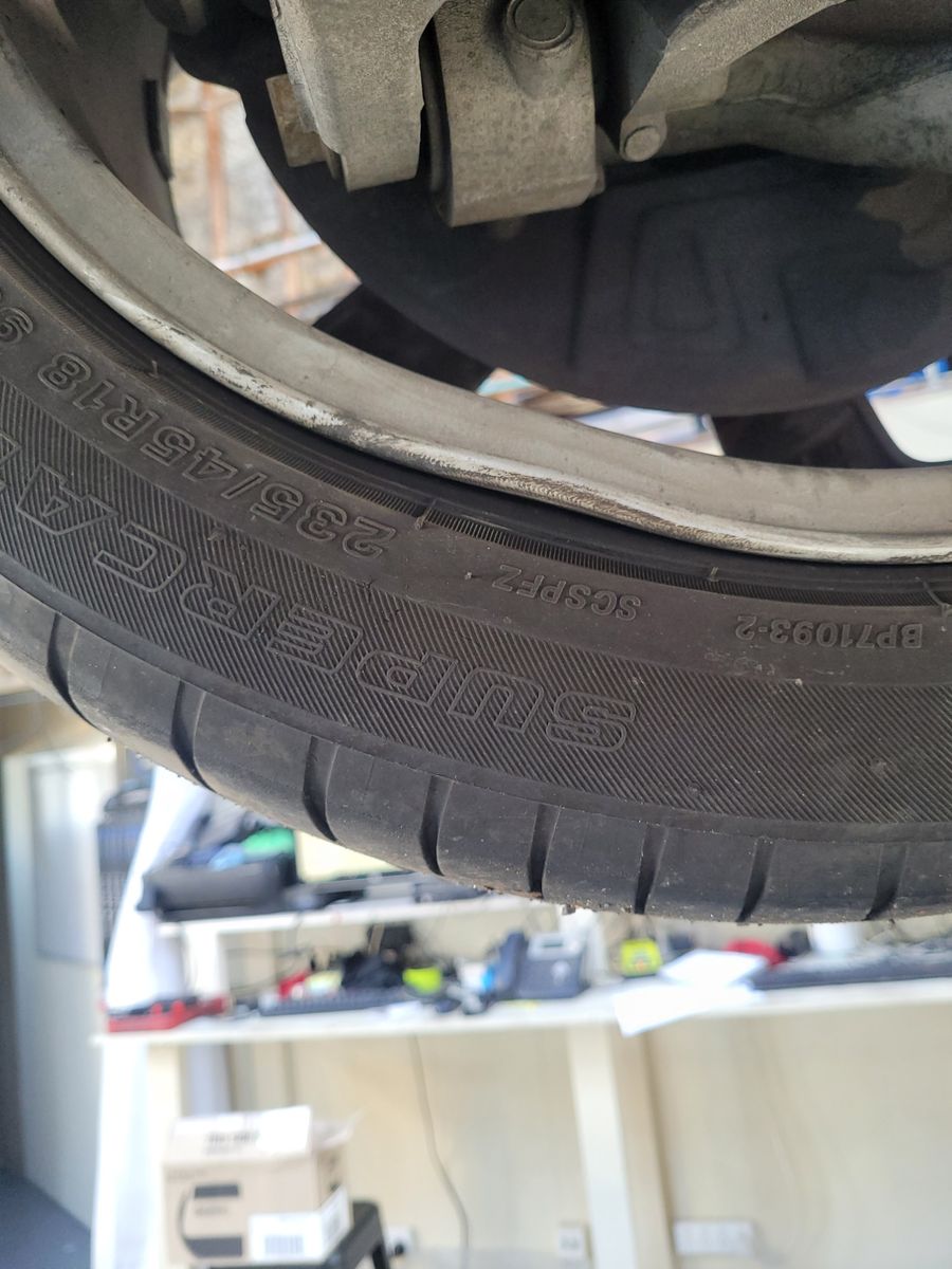 Bent Alloy Wheel Close-Up Bent alloy wheel rim with visible curb damage