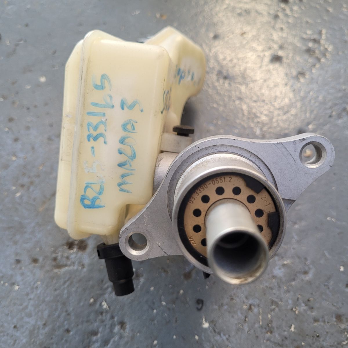 Mazda 3 Brake Master Cylinder Pump Close-Up Front view of a Mazda 3 brake master pump on a garage floor