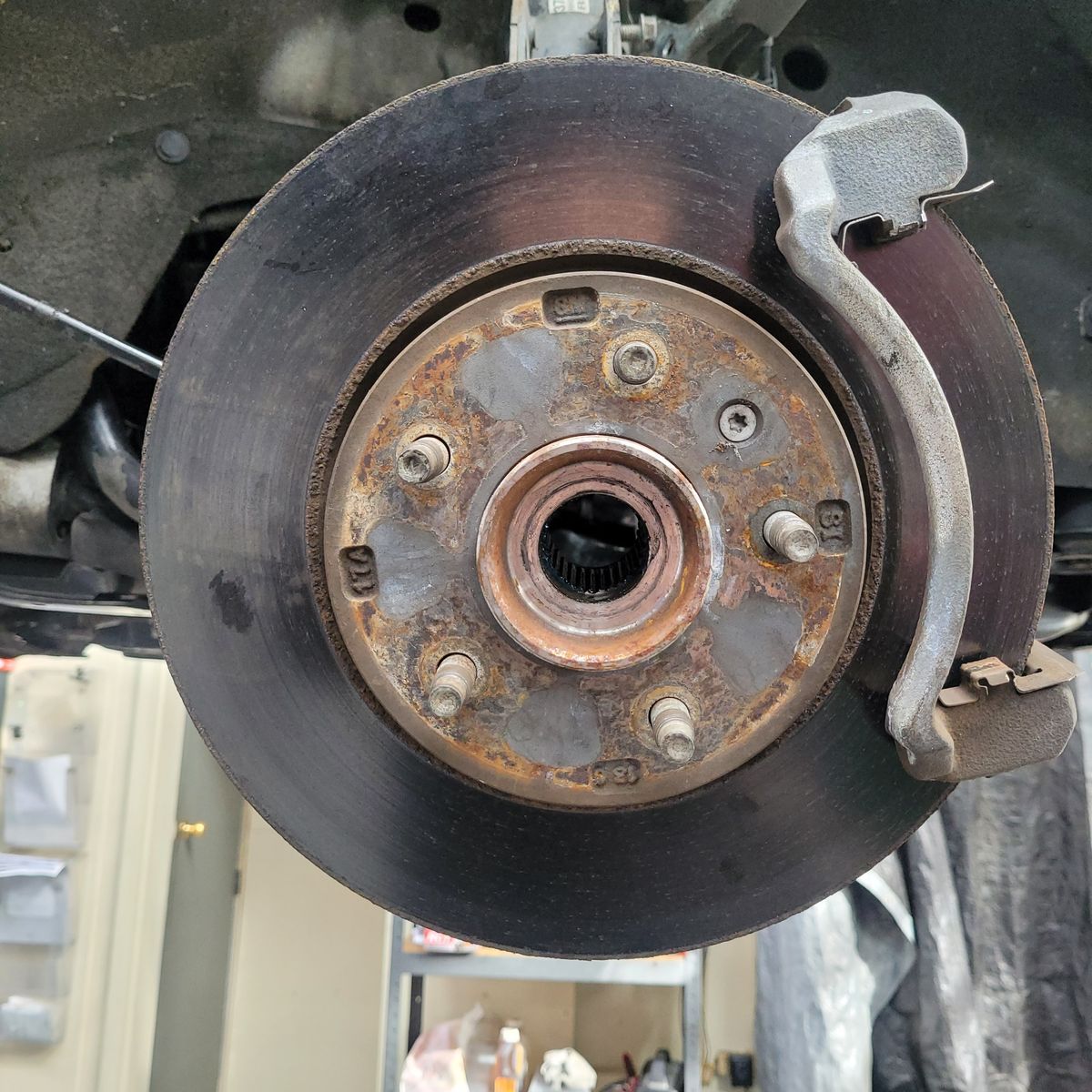Close-up of a Car Brake Rotor and Caliper Rusty car brake rotor and caliper assembly viewed from the front wheel hub