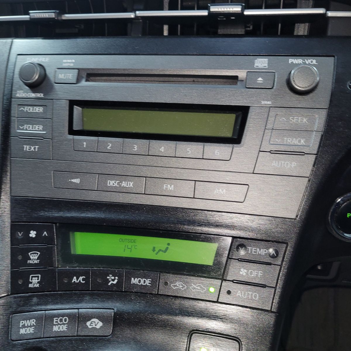 Close-up of a car radio and climate control panel with display screens.
