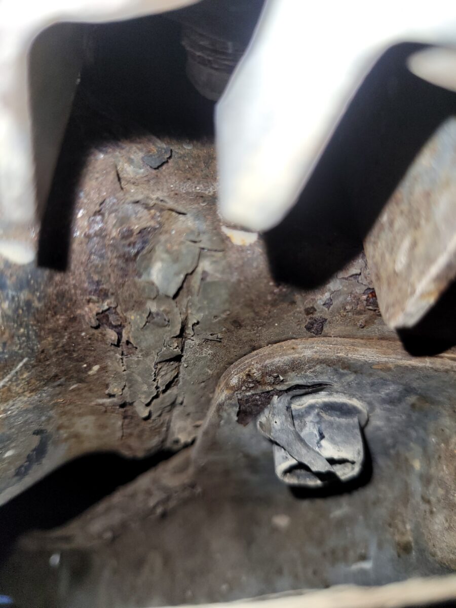Close-up of corroded metal with peeling paint and a bolt. Close-up of corroded metal with peeling paint and a bolt.