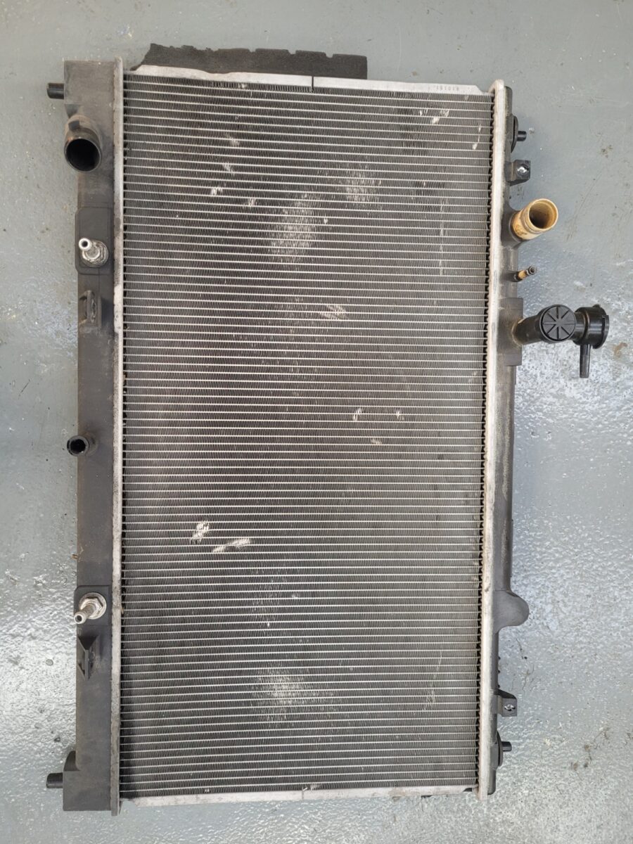A used car radiator with a black plastic frame. A used car radiator with a black plastic frame.