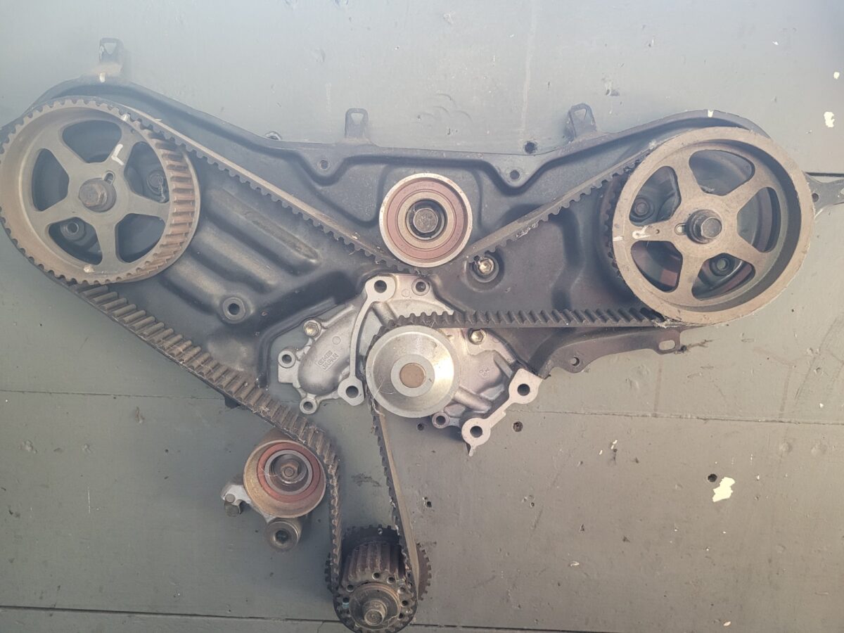 Engine timing belt and pulleys, showing the mechanical components.