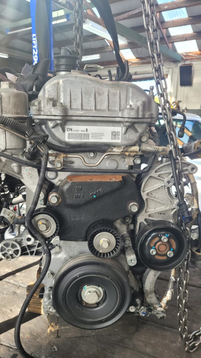 A used car engine is suspended by chains. A used car engine is suspended by chains.