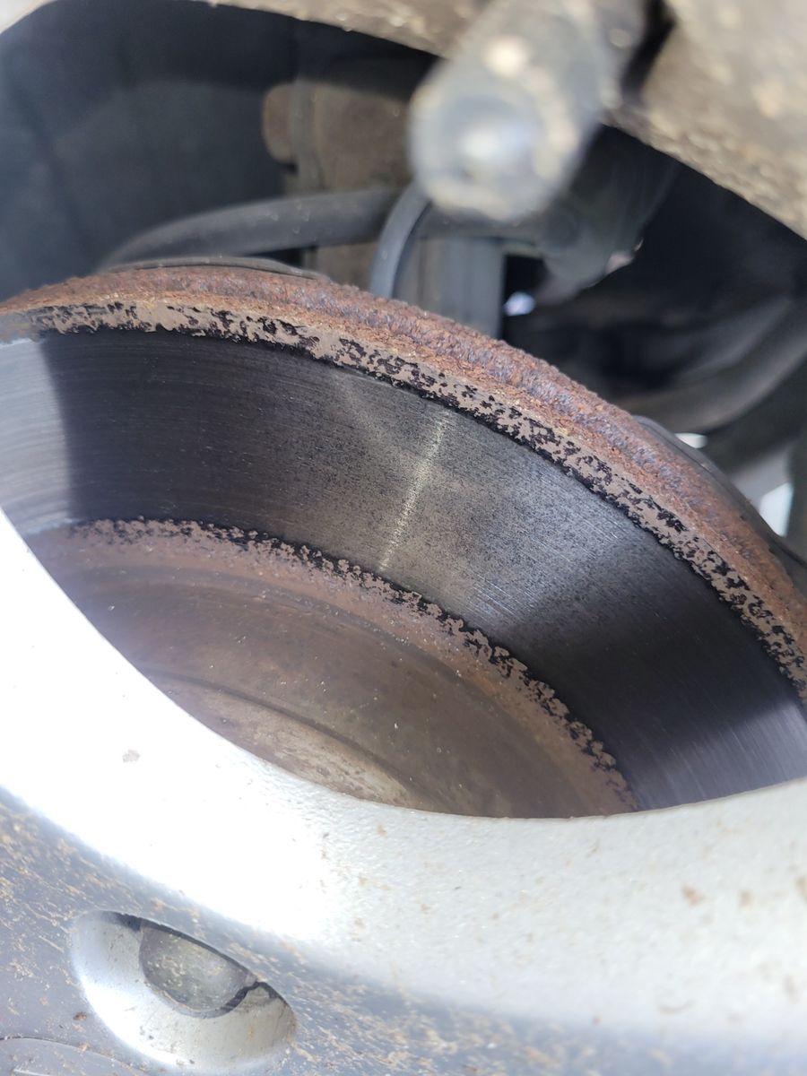 Worn Front Brake Disc with Rust Buildup Close-up of a car's front brake disc showing rust and wear