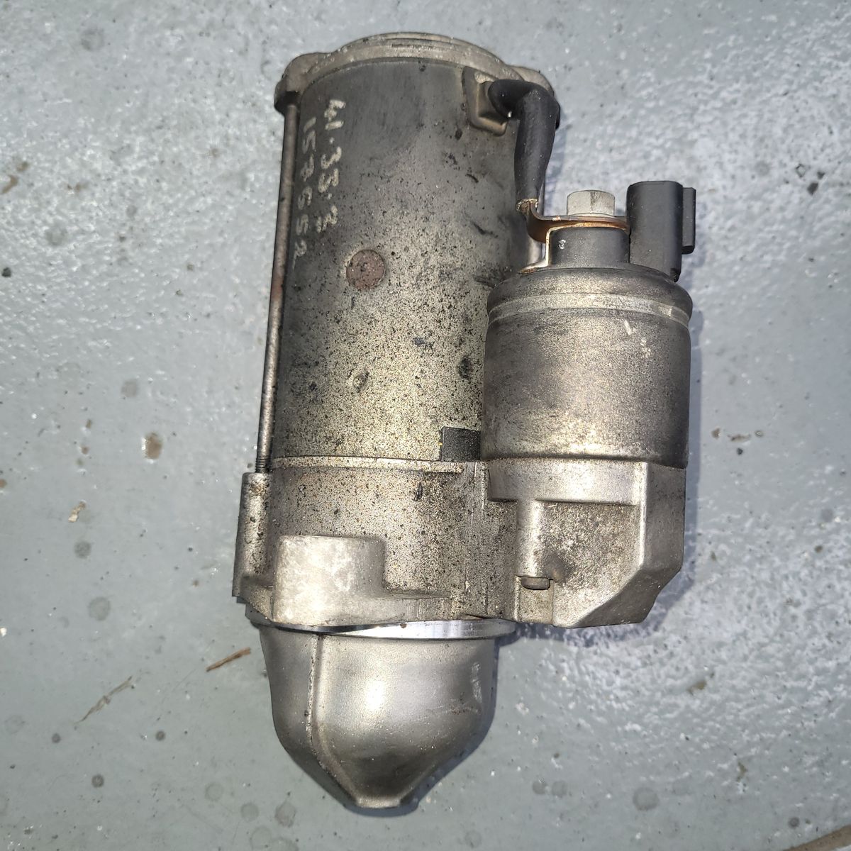 Close-up of a metallic car starter motor with visible wear marks