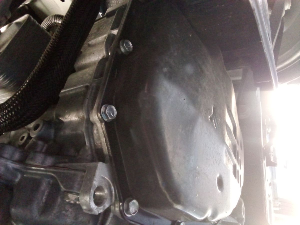 Close-up of automatic transmission pan under a vehicle Transmission pan bolted to underside of vehicle, ready for fluid change