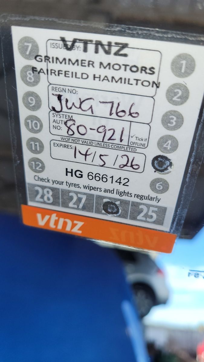 WOF sticker from VTNZ Grimmer Motors, showing vehicle info and expiry date.