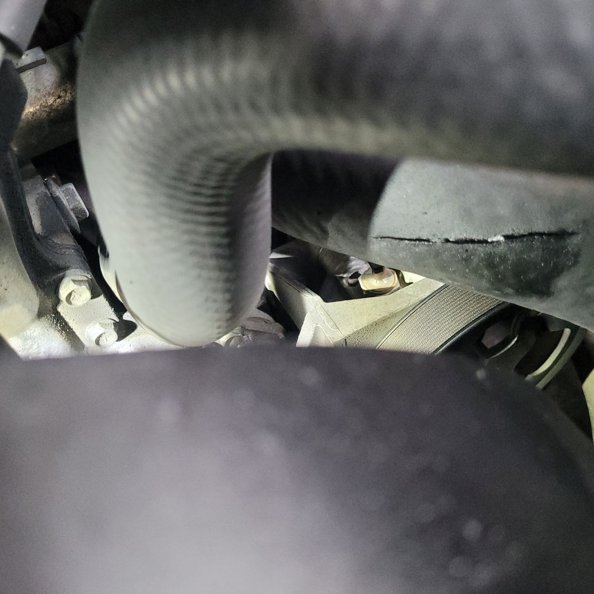 Cracked Air Intake Hose in Engine Bay Close-up of cracked air intake hose inside a car engine compartment