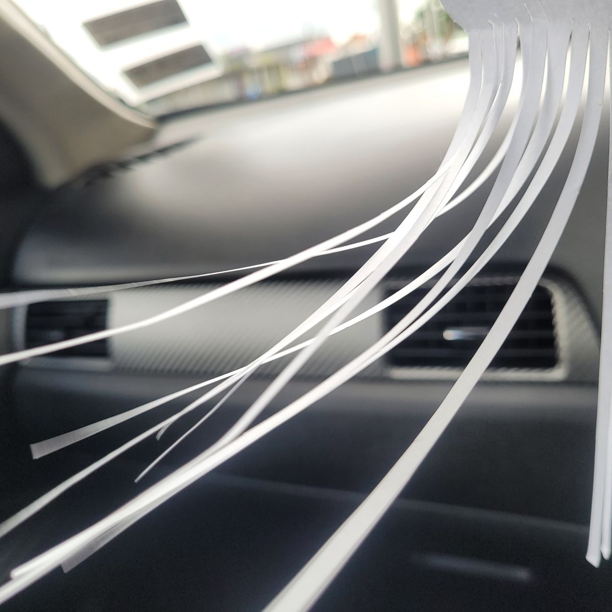 Air Flow Test with Strips at Car Air Vent Paper strips blowing in front of a car's dashboard air vent