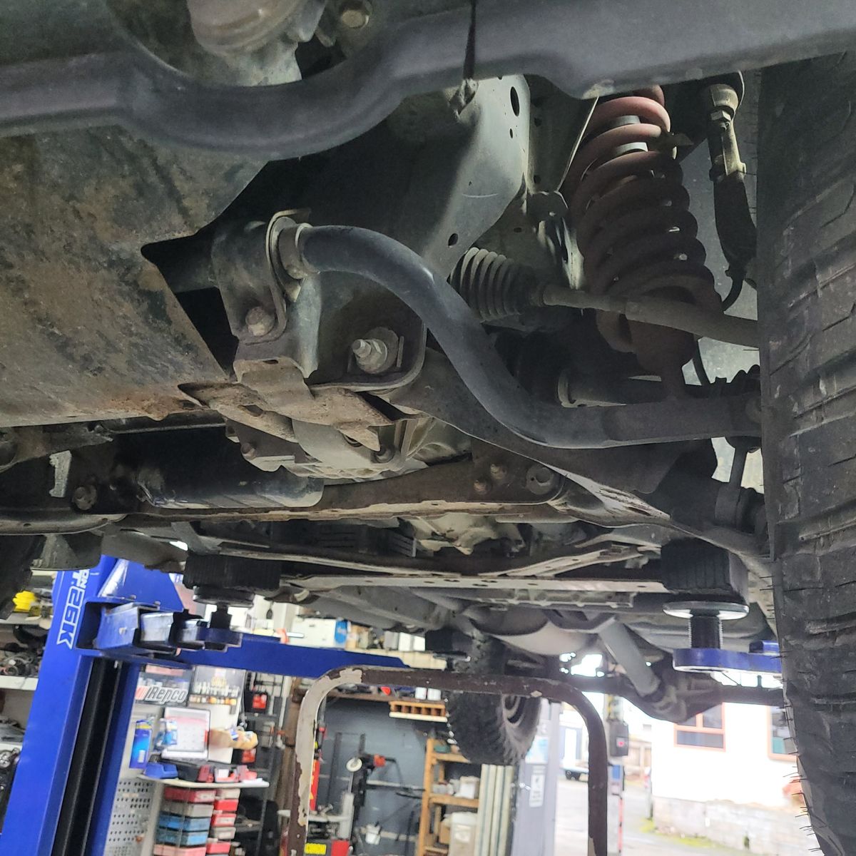 Vehicle Anti-Roll Bar and Suspension Components Close-up of a vehicle's anti-roll bar and suspension on a lift