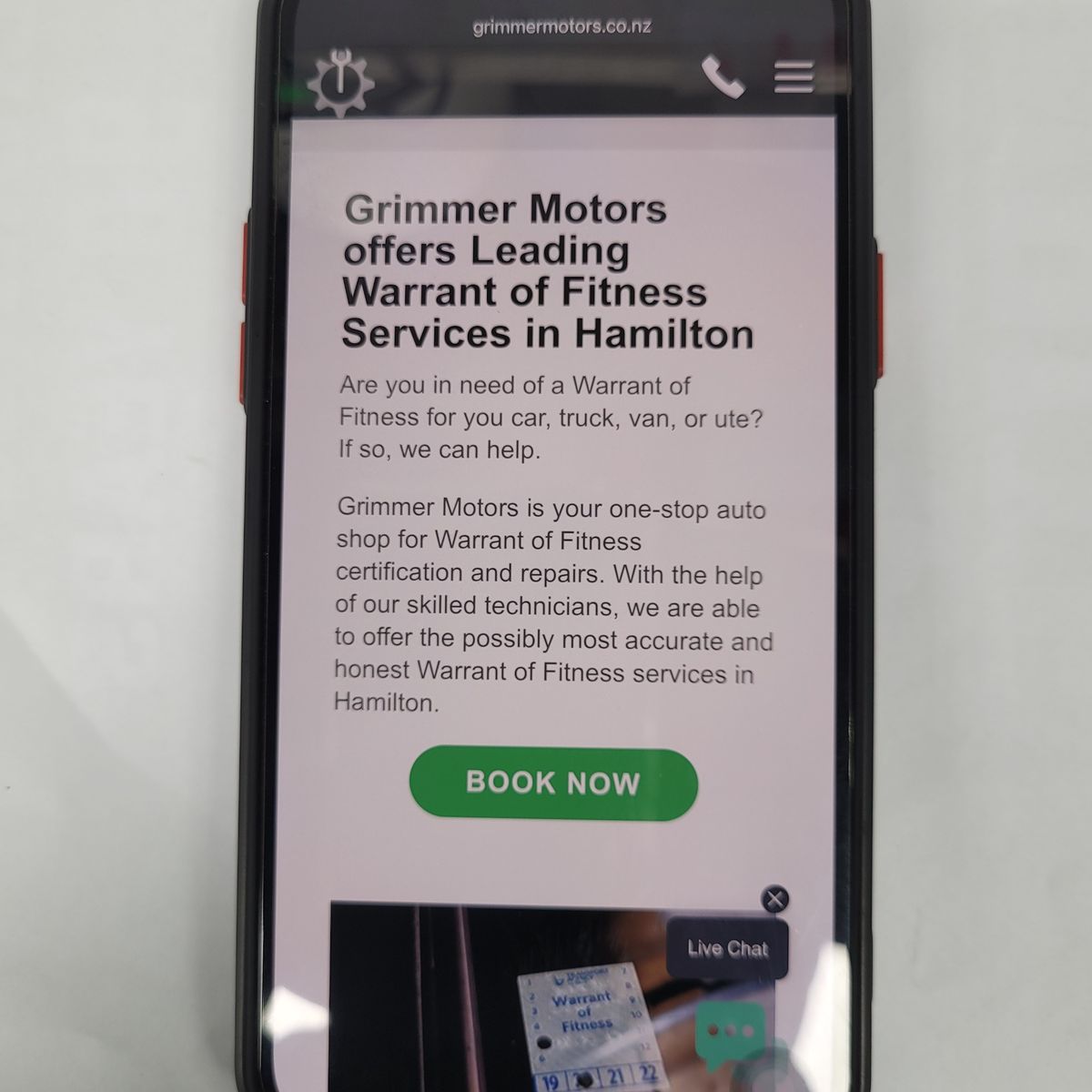 Smartphone displaying Grimmer Motors' online Warrant of Fitness booking page.