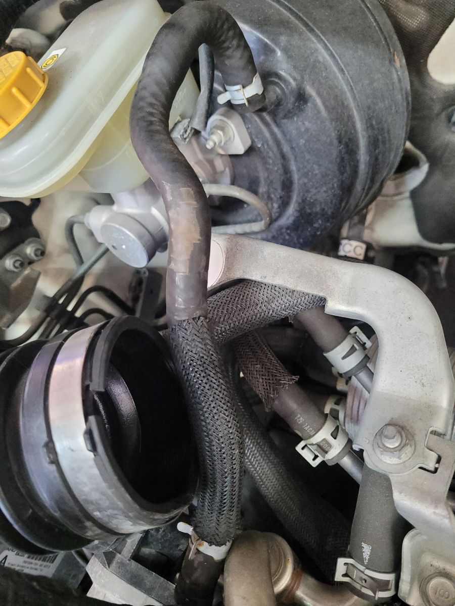 Brake Booster Vacuum Hose in Car Engine Bay Close view of brake booster vacuum hose connected in a car engine bay