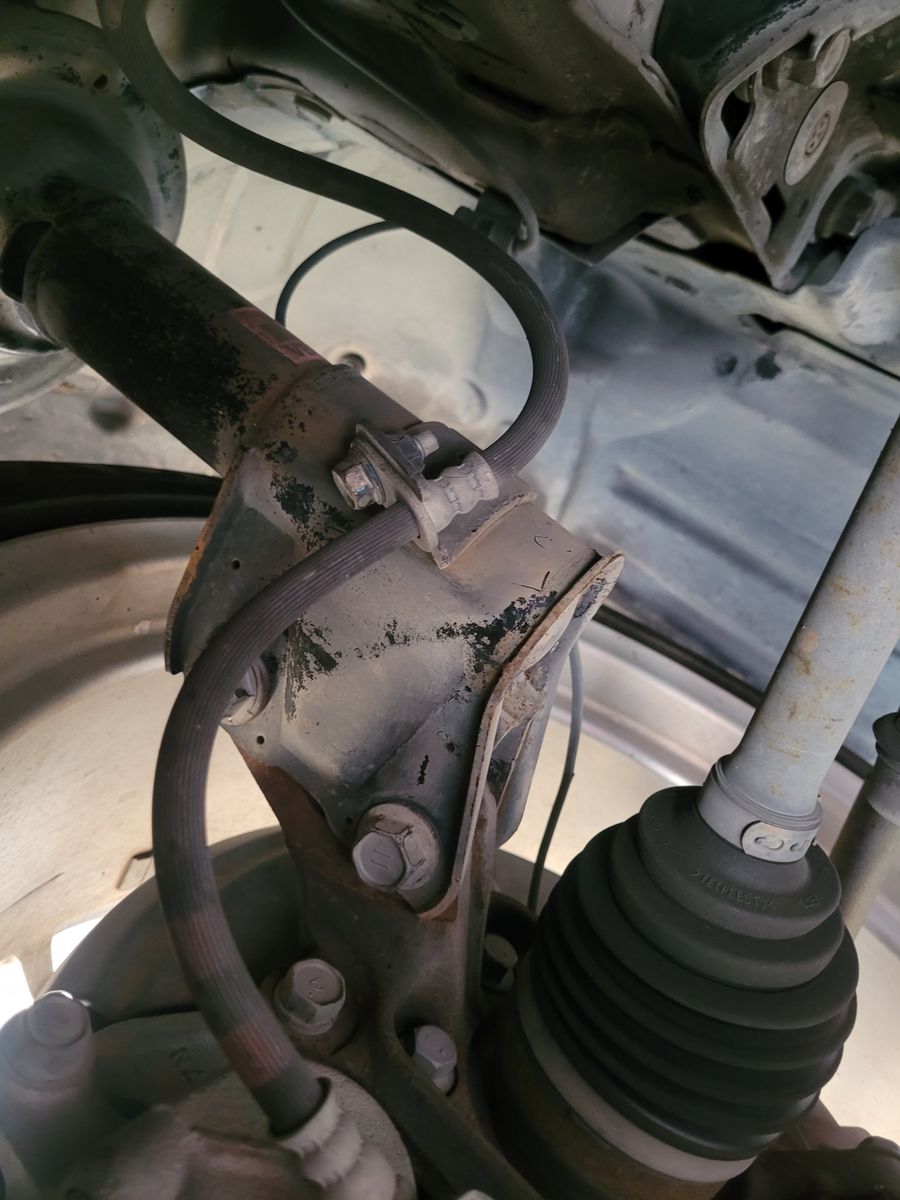 Close-Up of Car Brake Hose Assembly A detailed view of a car brake hose attached to a suspension component.