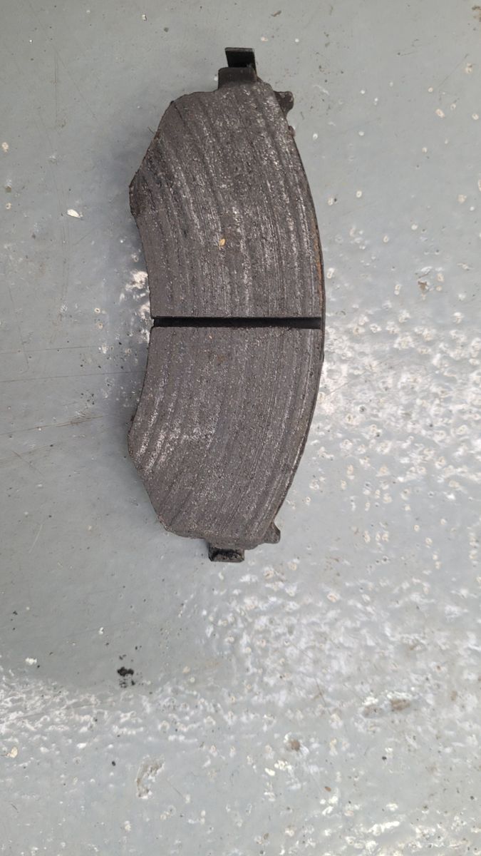 Worn Automotive Brake Pad Single used brake pad with visible grooves and wear