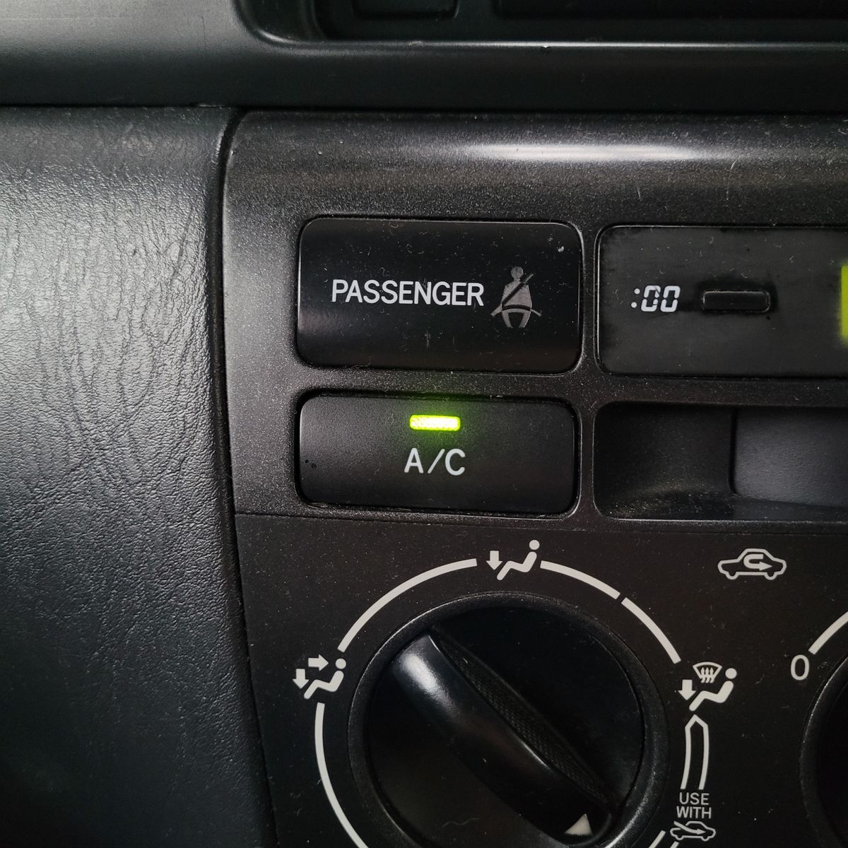 Car A/C Button with Indicator Light Activated A/C button with green light on car dashboard