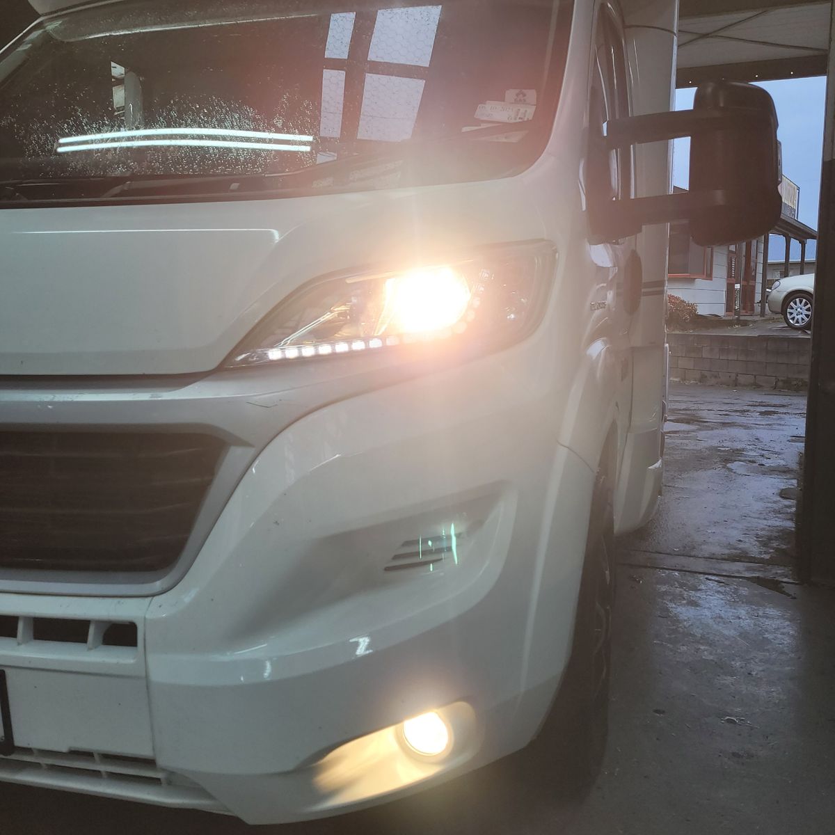 White Camper Van Headlights On Front view of a white camper van with headlights and fog lights on