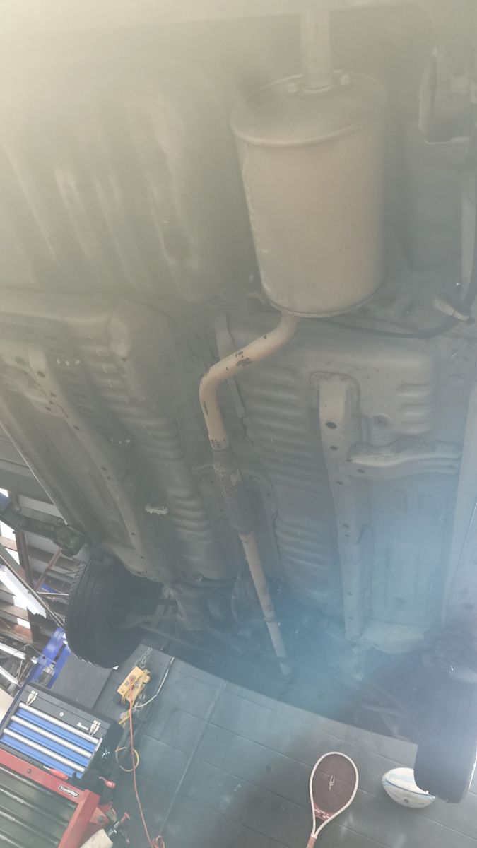 Clean Car Underbody on Lift in Workshop The clean underbody of a car on a lift, seen in a workshop setting