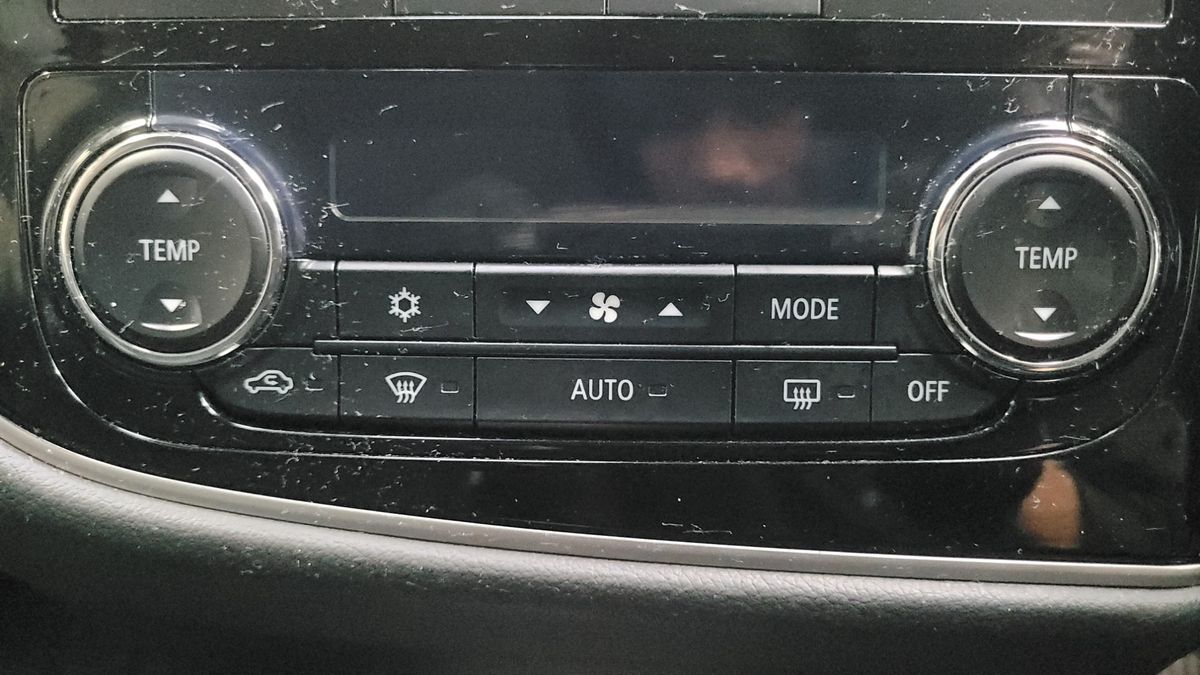 Car climate control panel with temperature, fan, and mode buttons.
