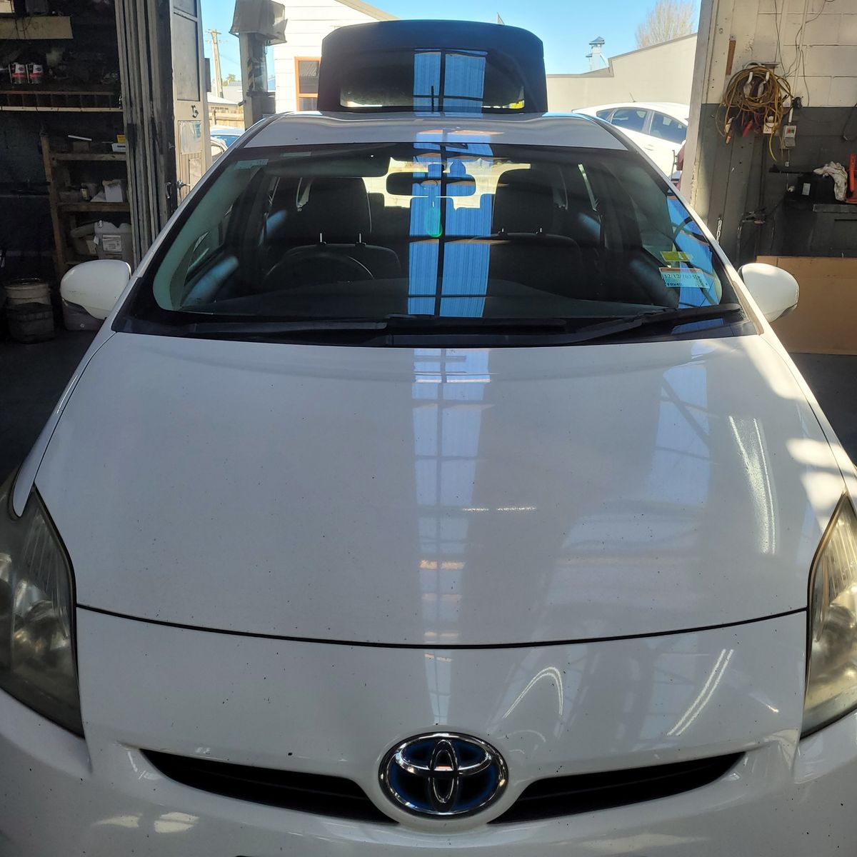Closed Bonnet of a White Toyota Prius Front view of a closed white Toyota Prius bonnet inside a garage