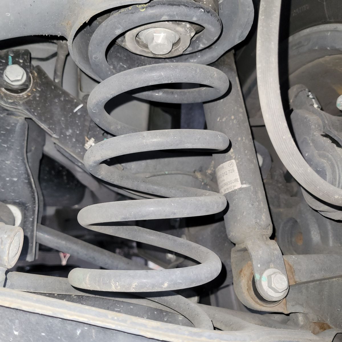 Automotive Coil Spring Suspension Close-up Close-up of a car's coil spring suspension system with bolts and metal arms visible