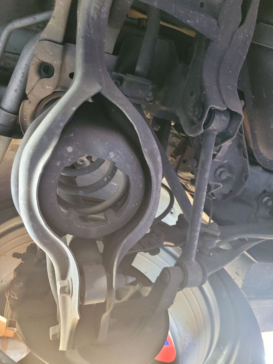 Close-up of a vehicle control arm with attached suspension components