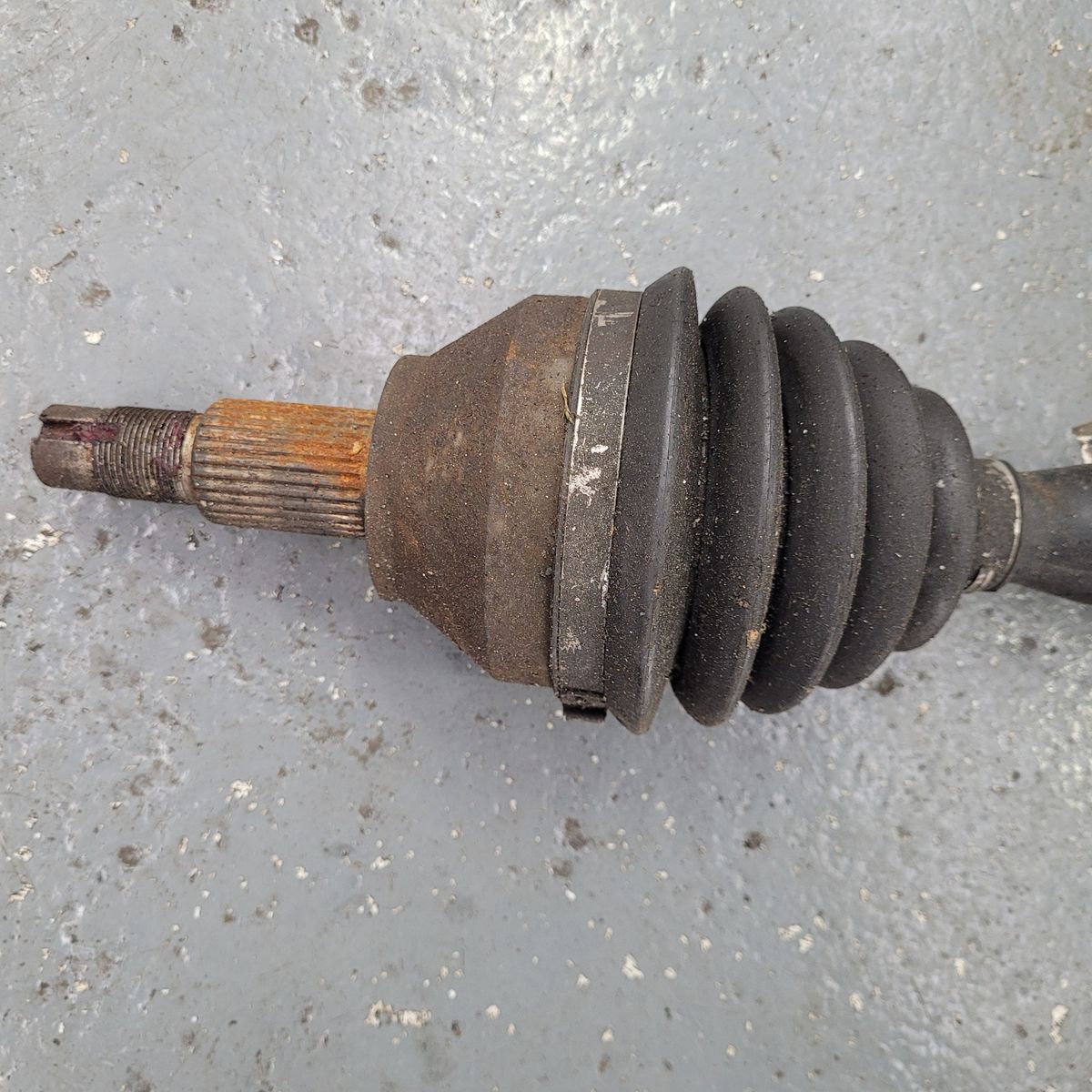 Used CV Joint With Rubber Boot A close-up of a used CV joint with a black rubber boot