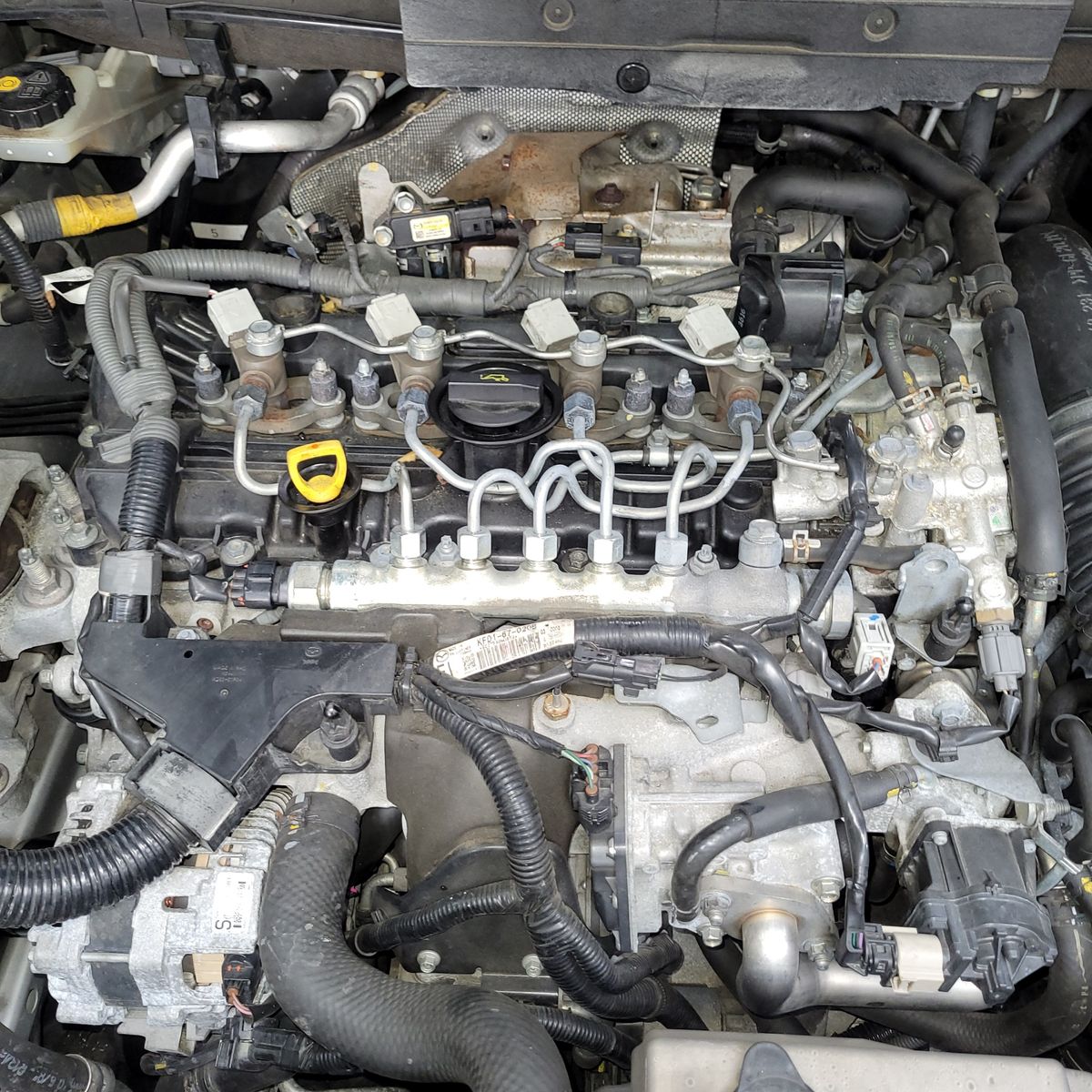 Detailed diesel engine with visible fuel lines and wiring under hood.