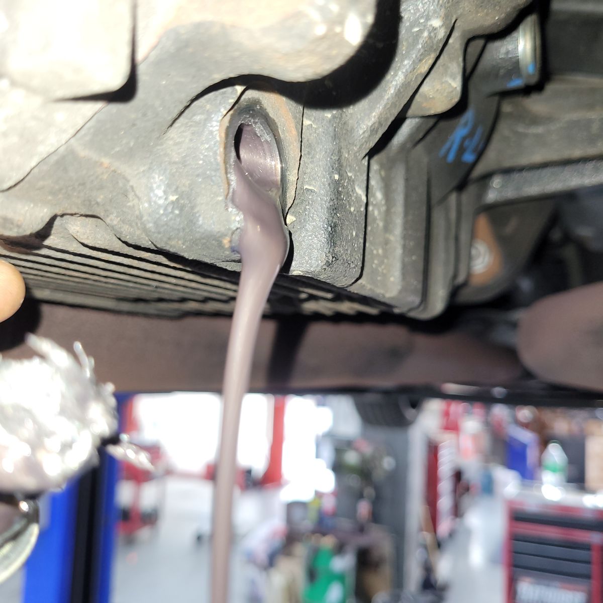 Draining Differential Oil from Vehicle A close-up of differential oil draining from a vehicle in a workshop.