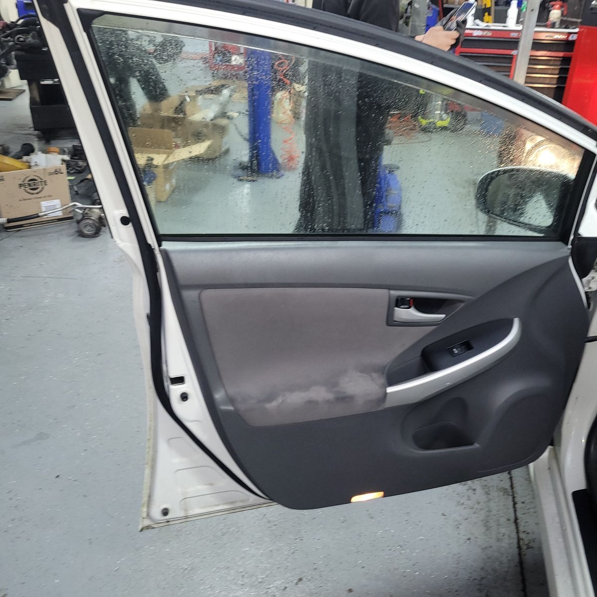 Car Door Glass with Rain in Workshop Car door open showing wet window glass in auto repair shop
