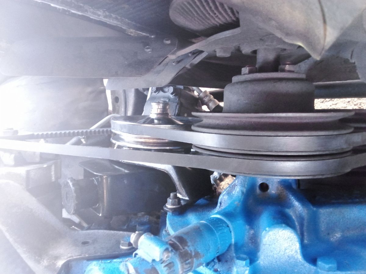 Close-Up of Drive Belt on Engine Pulley Drive belt wrapped around metal pulleys in a vehicle engine compartment.