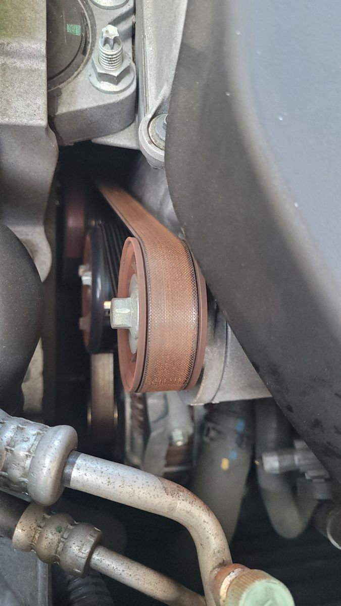 Close-up View of an Automotive Drive Belt Detail of a car engine's drive belt and pulleys.