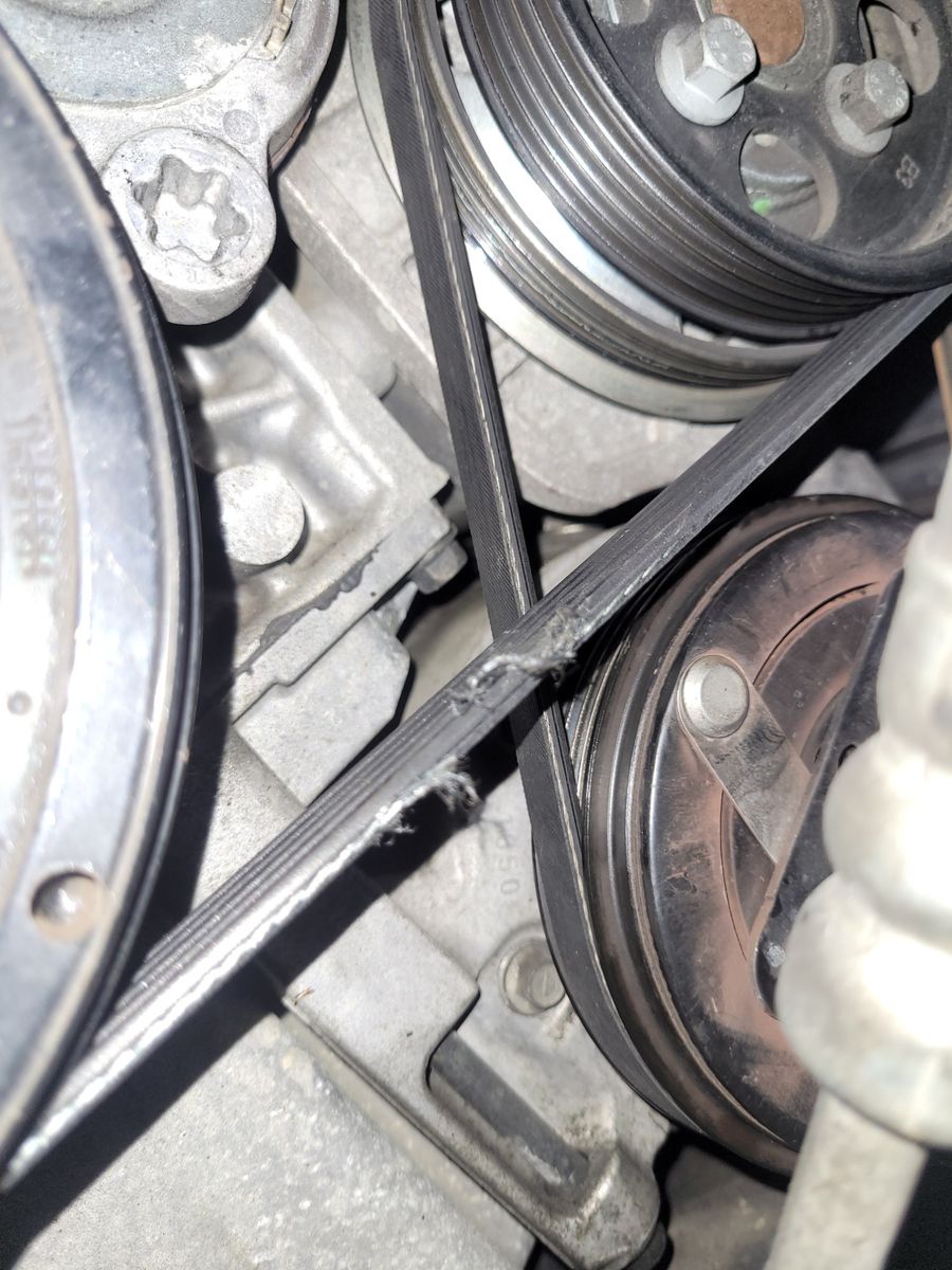 Damaged Drive Belt on Engine Pulley Worn and frayed drive belt on engine pulleys