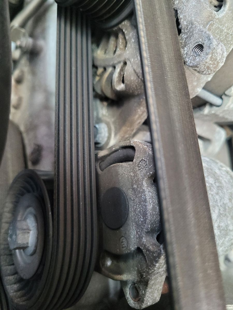 Close-Up View of a Car Drive Belt System Detailed shot of a car's serpentine drive belt and pulley system