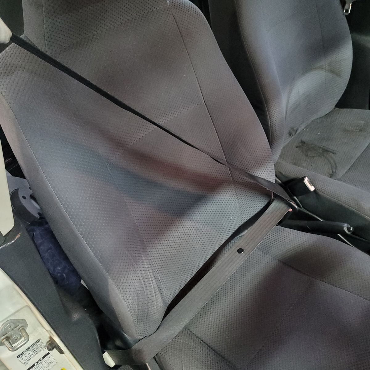 Driver Seat with Fastened Seatbelt Empty car driver's seat with seatbelt buckled across the seat