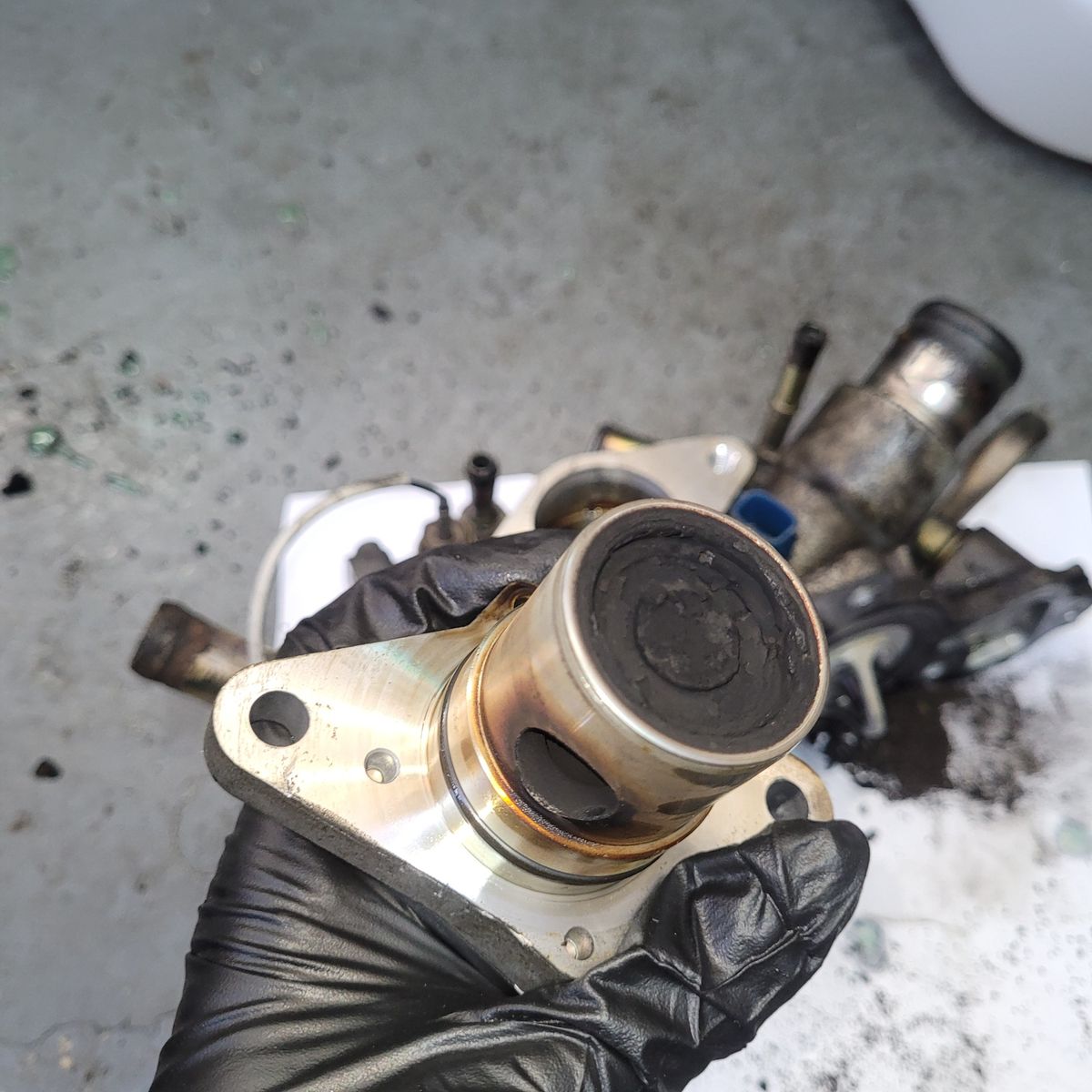 Dirty EGR Valve Close-up Dirty EGR valve with carbon buildup held in gloved hand
