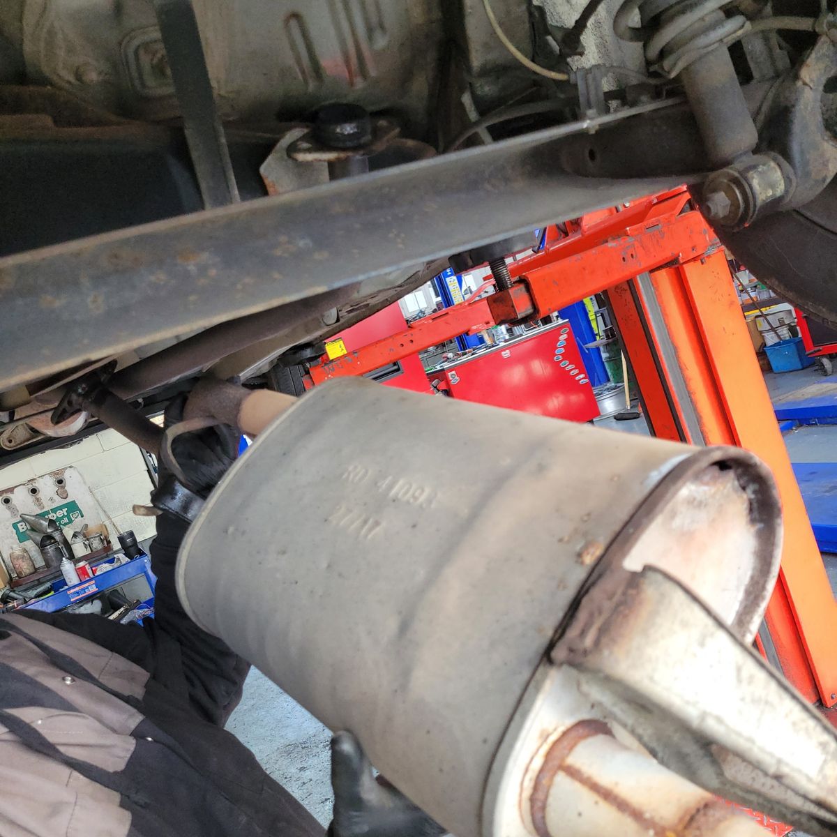 Mechanic Inspecting Exhaust Leak Mechanic working under car inspecting exhaust system leak.