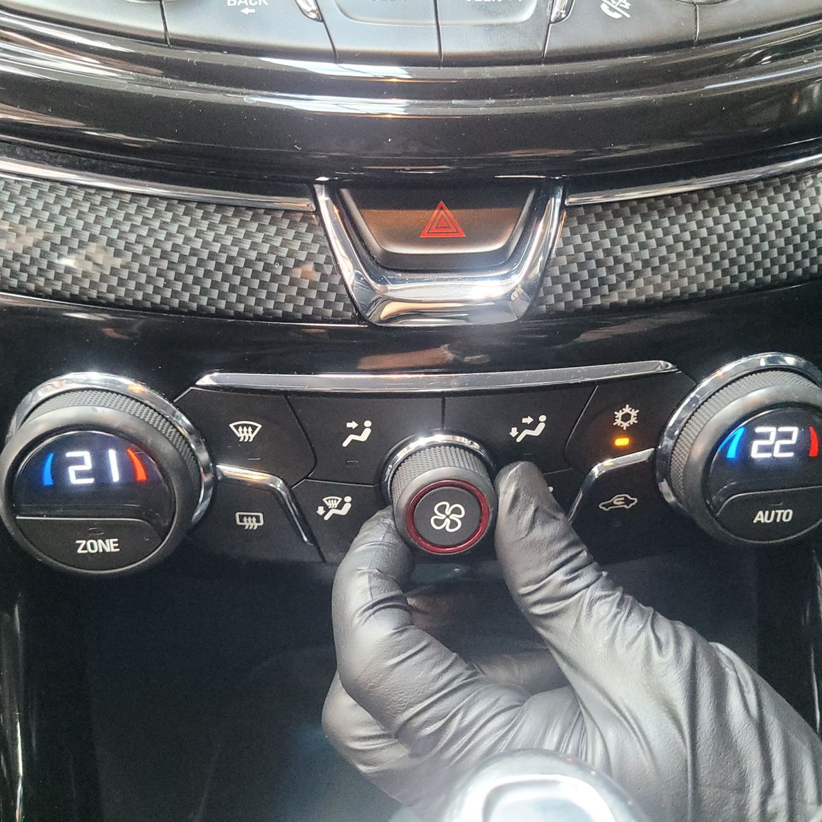 Adjusting Fan Level Control Switch in a Car Hand with black glove turning a car fan control knob