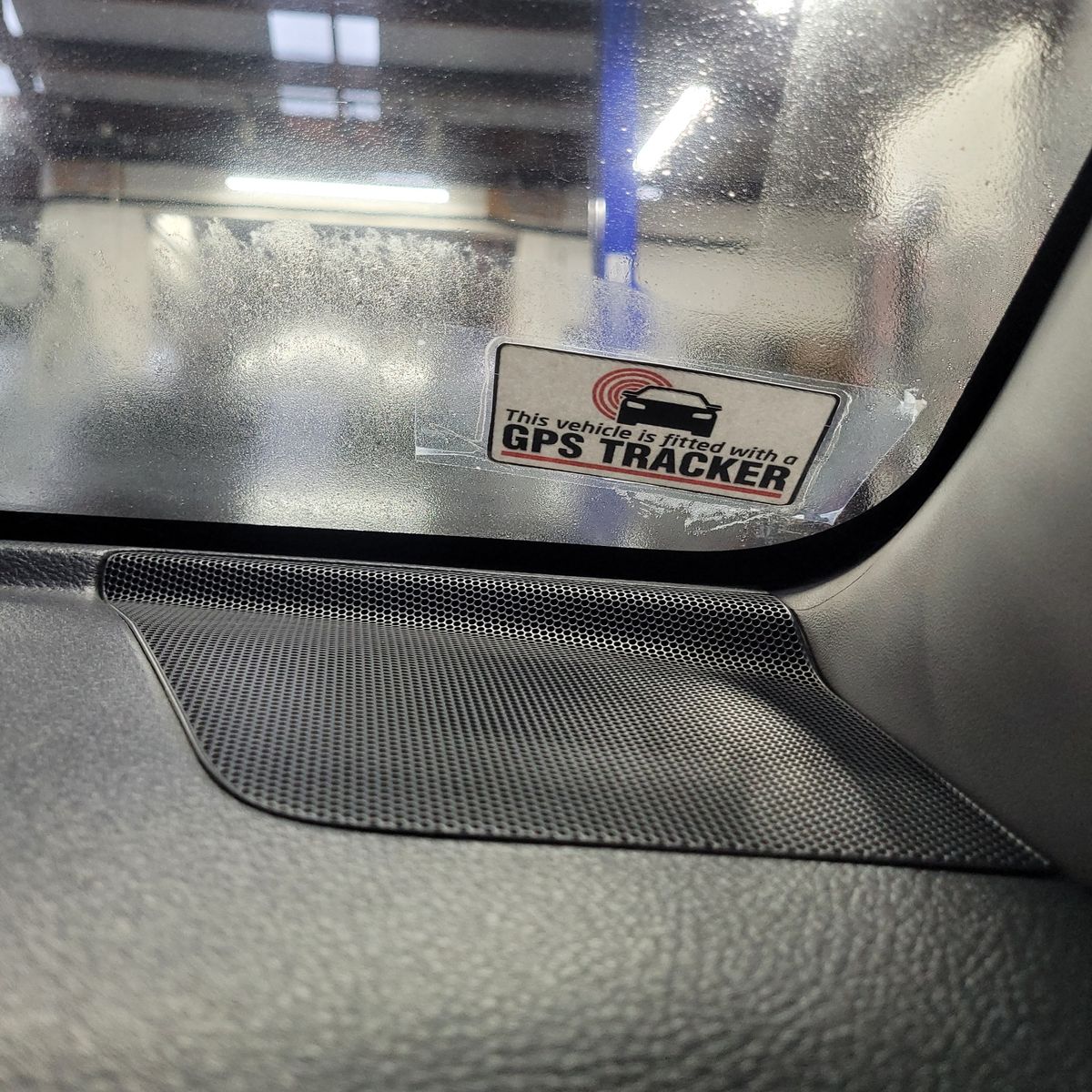 Sticker on a car window stating vehicle is fitted with GPS tracker.