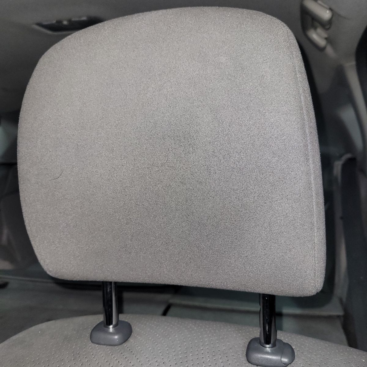 Close-Up of a Car Headrest Gray fabric car headrest with adjustable posts in vehicle interior