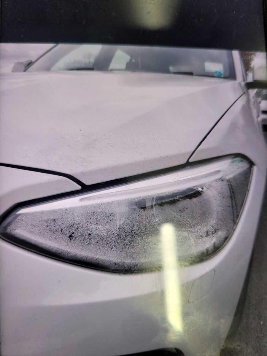 Close-up of Car Headlight with Condensation Fogged-up headlight assembly on a white modern car