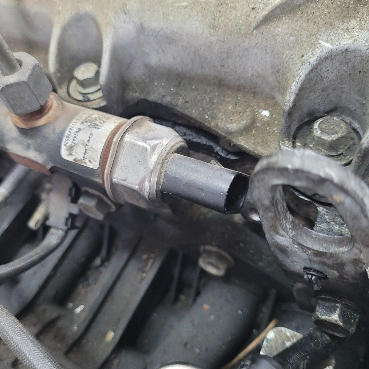 Close-up of a High-Pressure Rail Sensor in an Engine High-pressure rail sensor attached to an engine fuel rail.