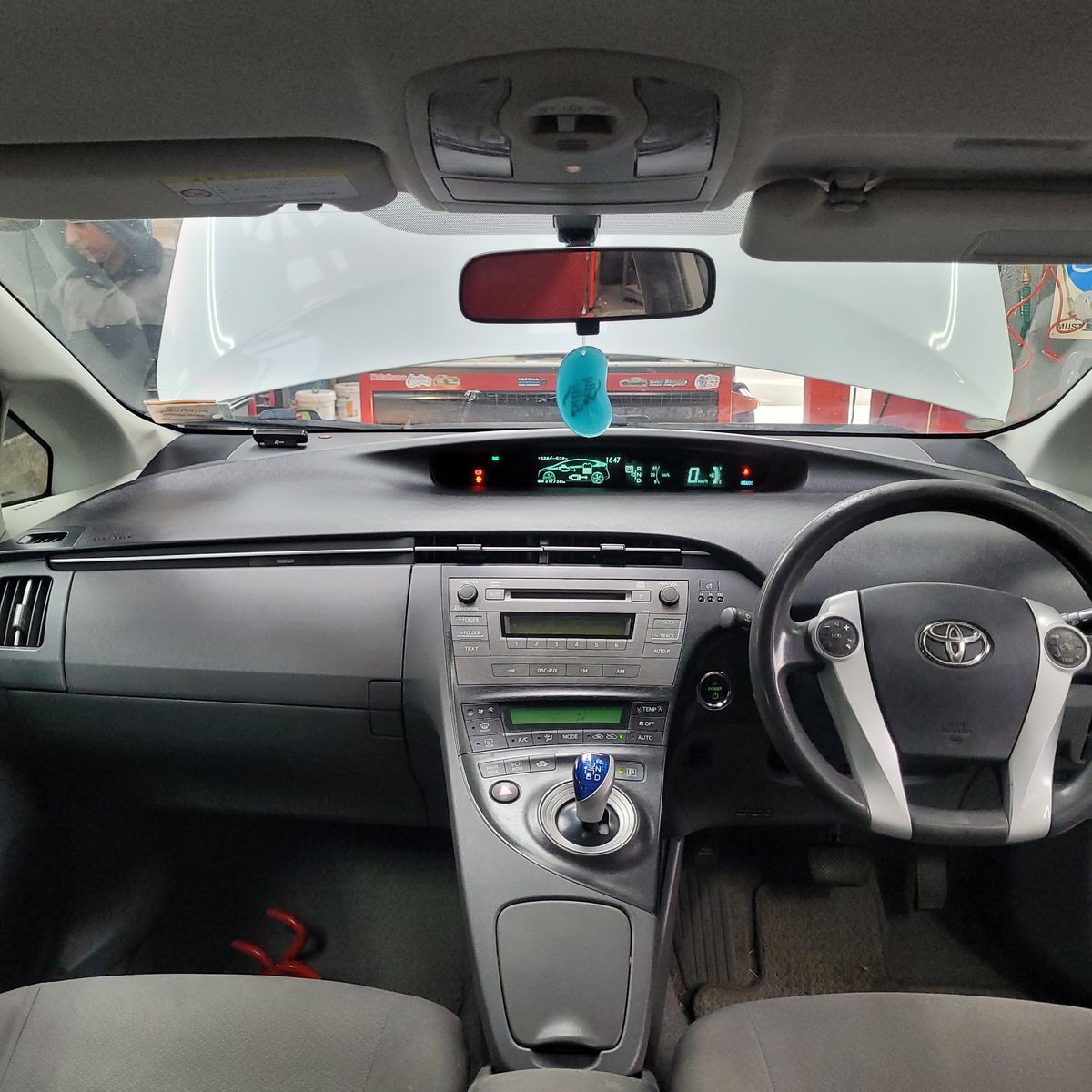 Interior View of Hybrid Car from Driver’s Seat Dashboard and steering wheel of a Toyota hybrid car with hood open