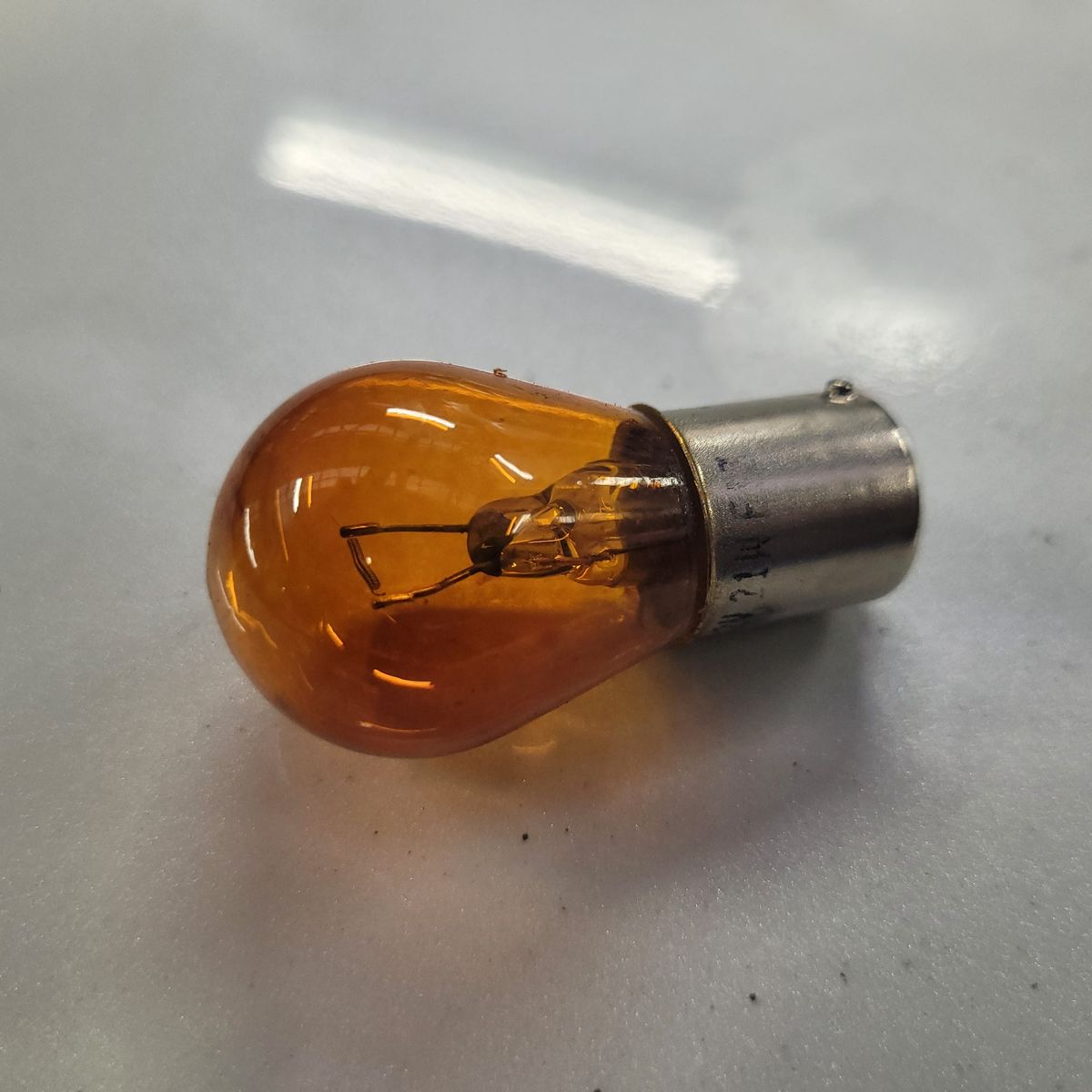 Amber Indicator Light Bulb Close-up of an amber automotive indicator light bulb on a smooth surface