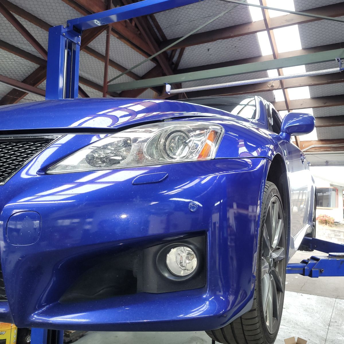 Lexus on Lift for Service Blue Lexus car elevated on hydraulic lift in auto repair shop