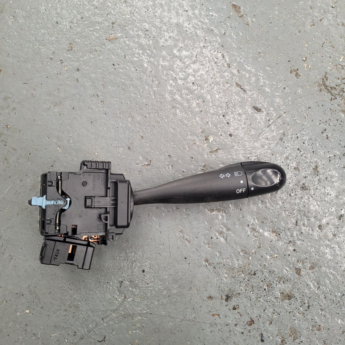 Black car headlight and turn signal switch lever on gray surface