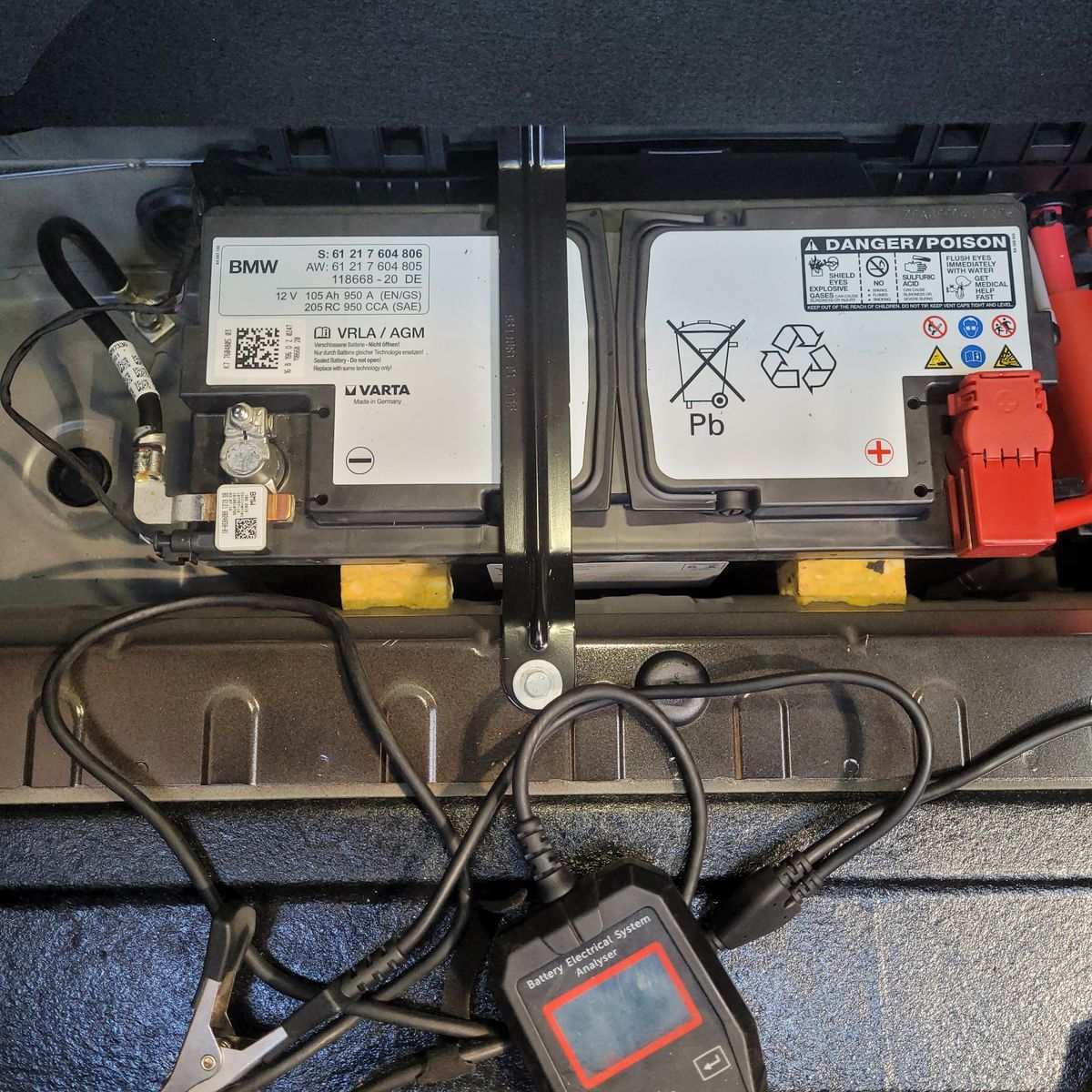 BMW 12V Car Battery Replacement Close-up of a BMW 12V car battery with attached test analyzer