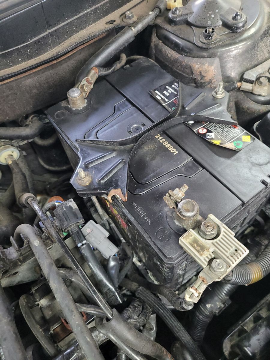 12V Car Battery in Engine Bay Close-up of a 12V car battery installed under the hood.