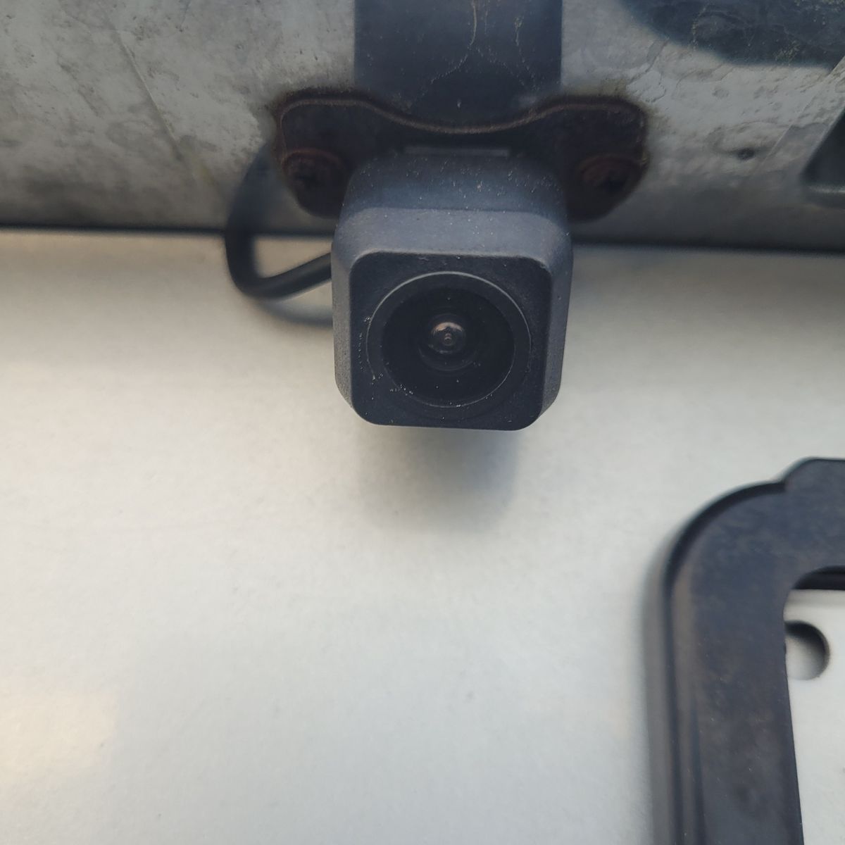 Square reversing camera mounted on a car near license plate area